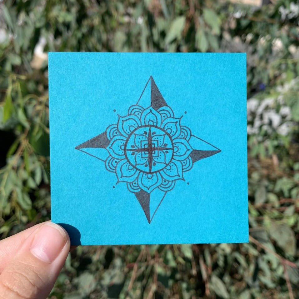 this original drawing (done by Thempress Tori Arnold) is a mandala zentangle inspired symmetrical compass design done on bright blue paper, evoking a feeling of inner peace and knowing