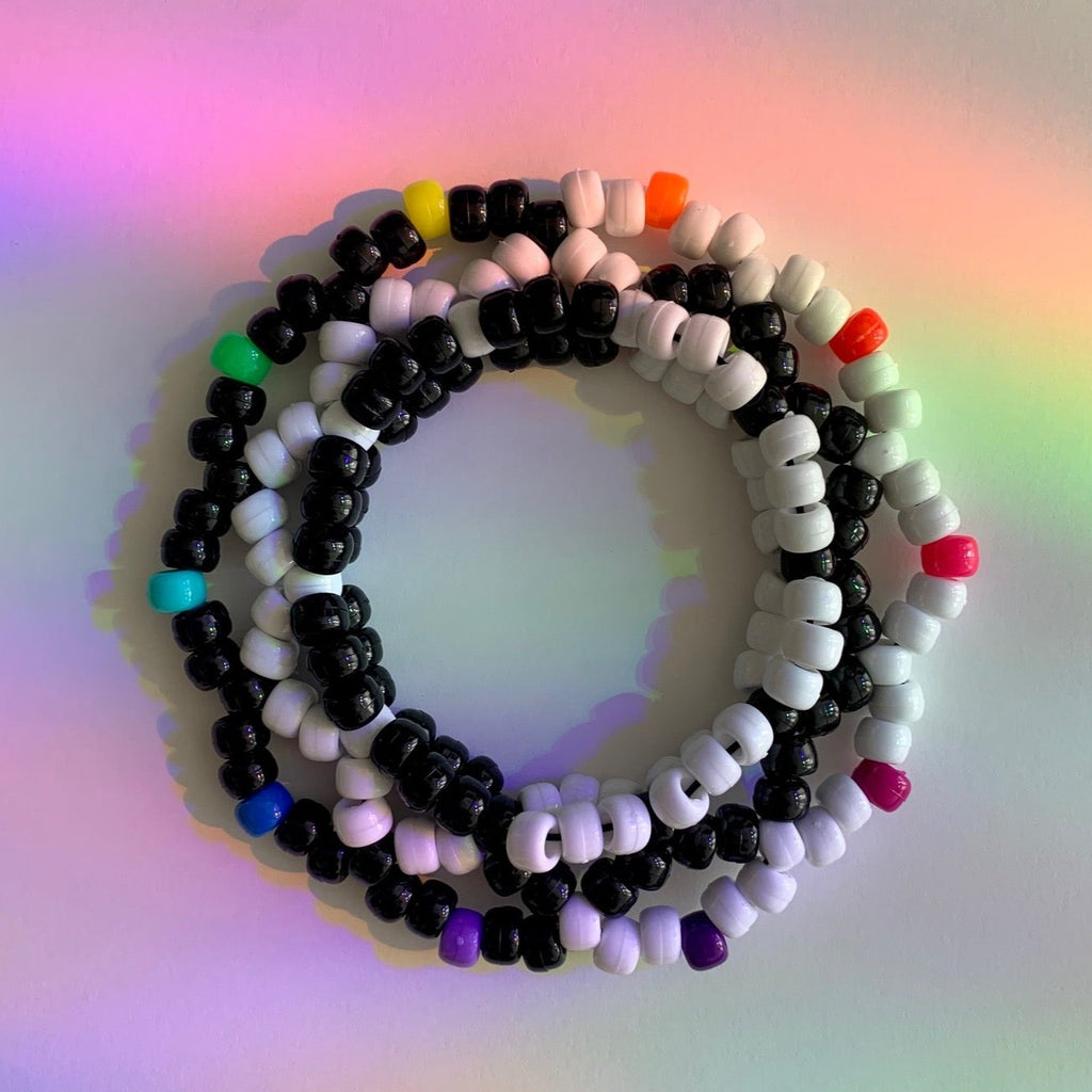 alternating black and white pony bead pattern was used throughout the rave kandi cuff to give a swirling yin yang type of design/effect. colorful rainbow beads top off the spikes on the end to add a fun, playful decorative touch